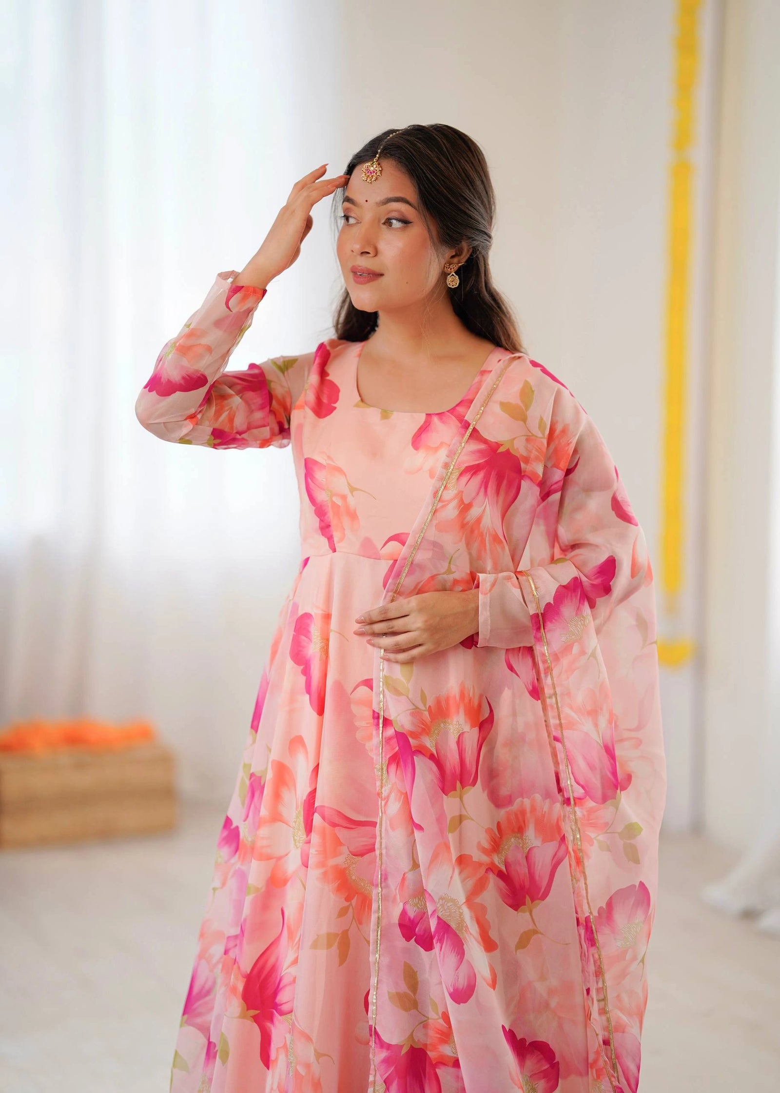 Woman wearing a pink floral dress with a blurred background