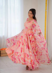 Woman wearing a long, floral-patterned dress in a bright room.