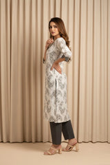 Woman wearing a white floral kurta with black pants against a beige curtain background