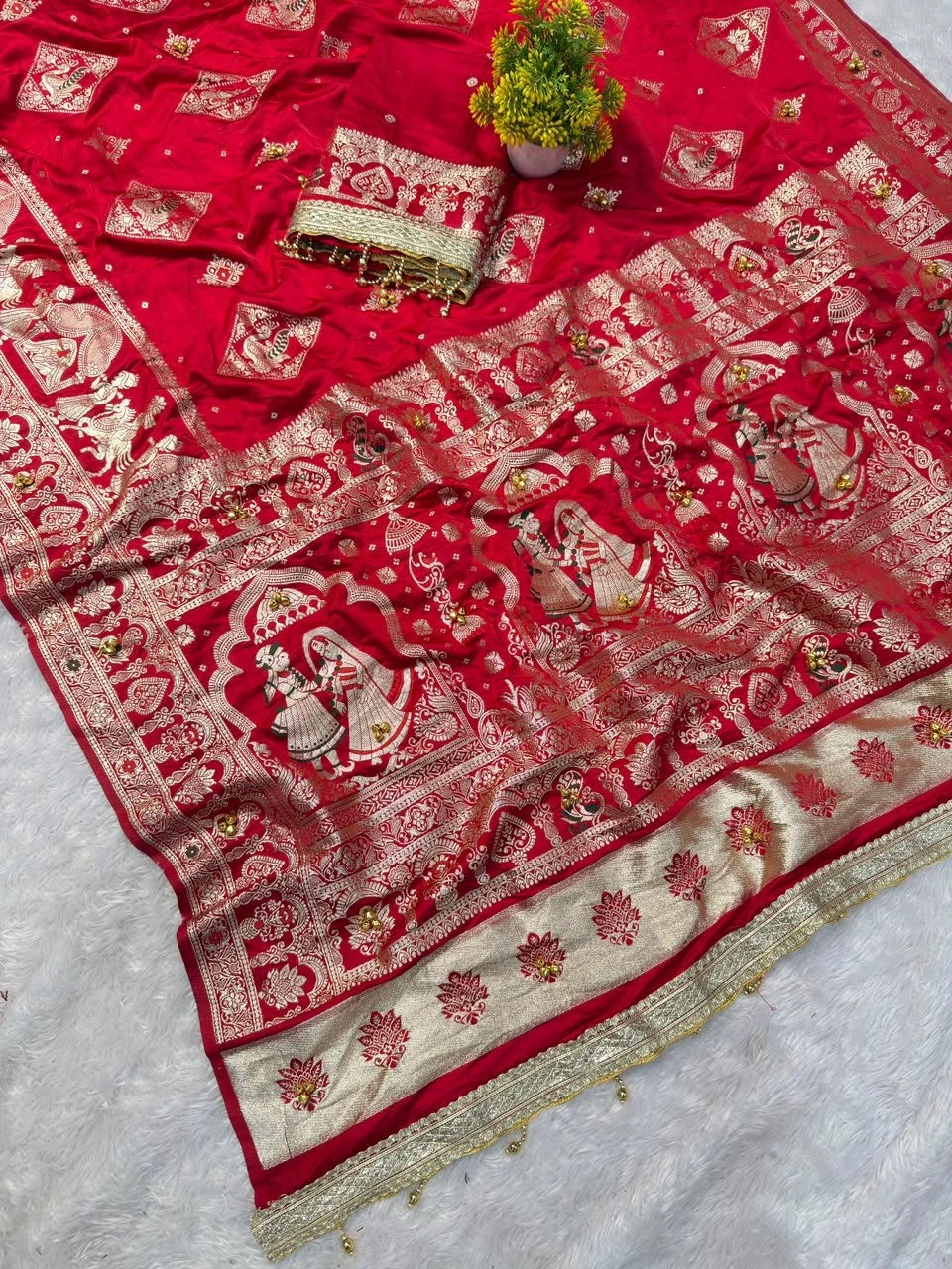 Red saree folded with zari bride and groom motif