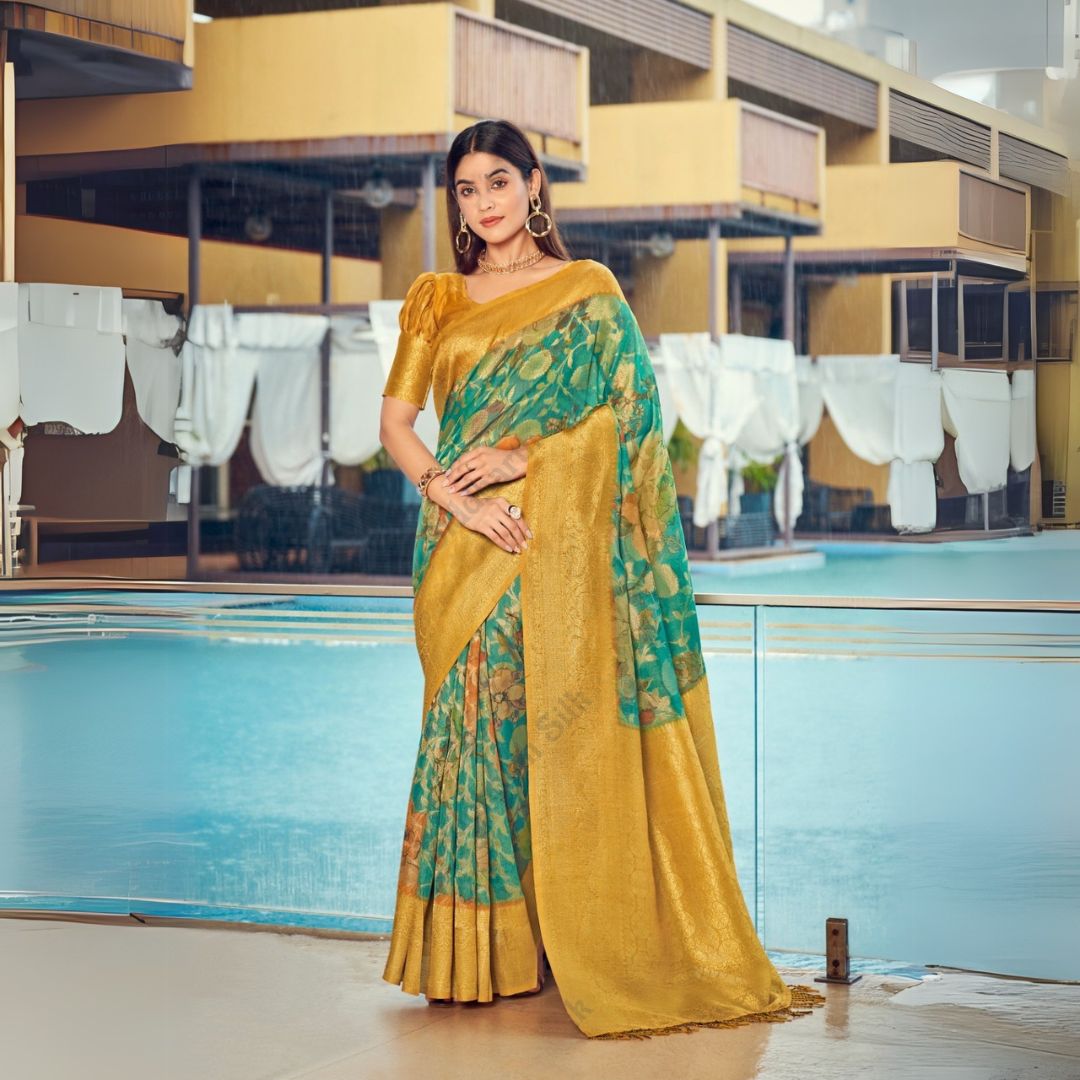 Woman in a tropical green zari work saree with floral patterns and golden pallu, styled elegantly with statement jewelry by the poolside