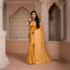 A woman models a vibrant Yellow Banglori Raw Silk Saree. The pallu and border feature dense, tone-on-tone Kalamkari-style weaving in gold Zari. She wears a yellow blouse and heavy dark gemstone jewelry, posing in an ornate, traditional setting.