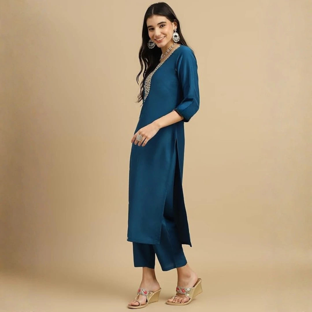 Woman wearing a teal kurta with a beige background