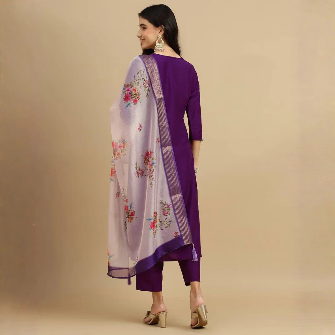 Woman wearing a purple outfit with a floral scarf on a beige background