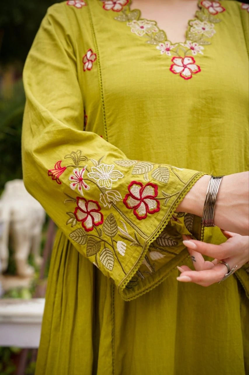 Green embroidered garment with floral patterns on a blurred background