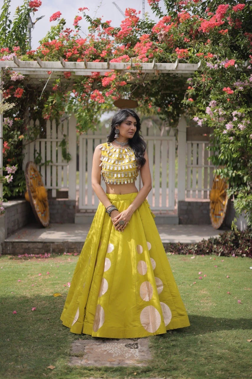 Gorgeous yellow lehenga with shimmering mirror embellishments and golden accents delivers timeless festive elegance for every celebration.