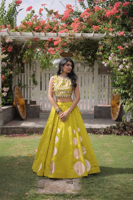 Gorgeous yellow lehenga with shimmering mirror embellishments and golden accents delivers timeless festive elegance for every celebration.