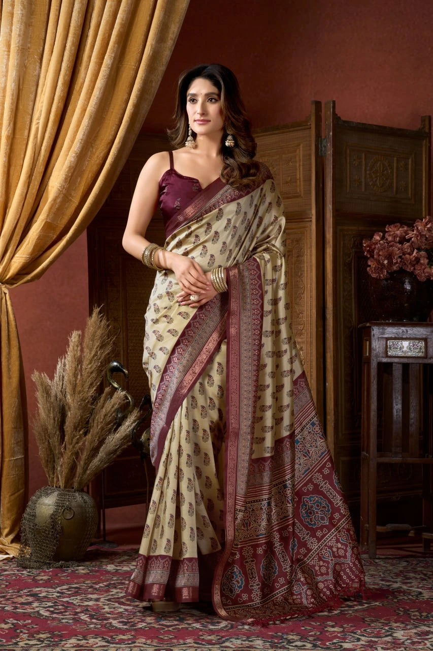 Woman in a traditional saree standing in an elegant room with curtains and decor.
