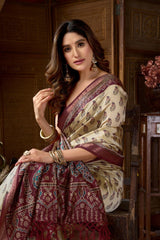 Woman in a traditional saree with intricate patterns in a warm-toned interior setting