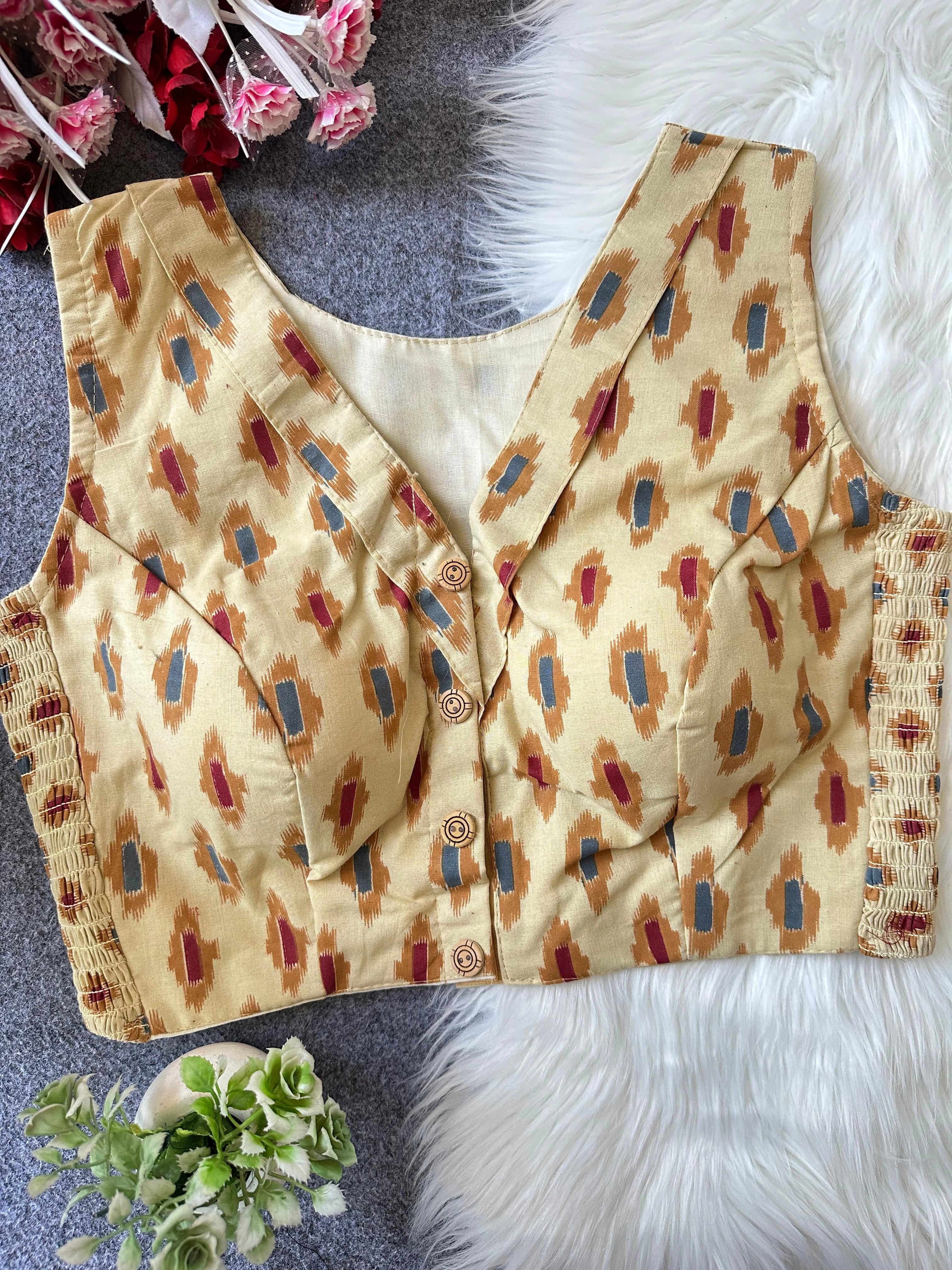 Beige patterned blouse with buttons on a textured surface