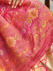 Close-up of a pink fabric with floral patterns and gold accents.