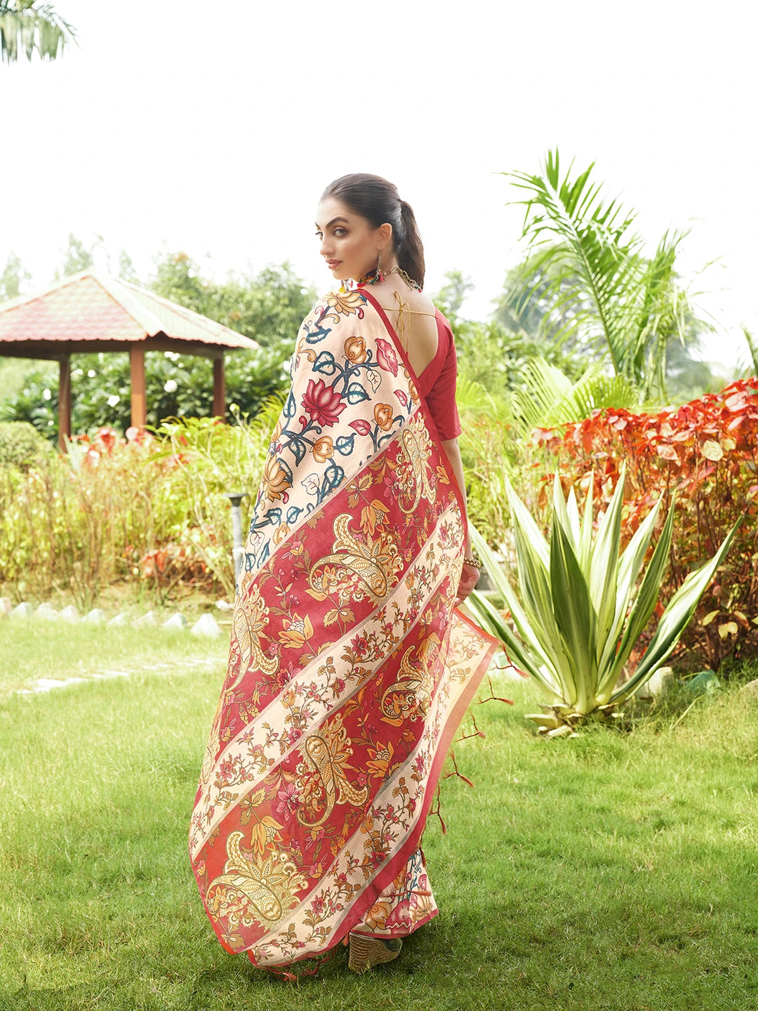 Traditional purple floral printed saree with artistic woven pallu and matching blouse showcased outdoors.