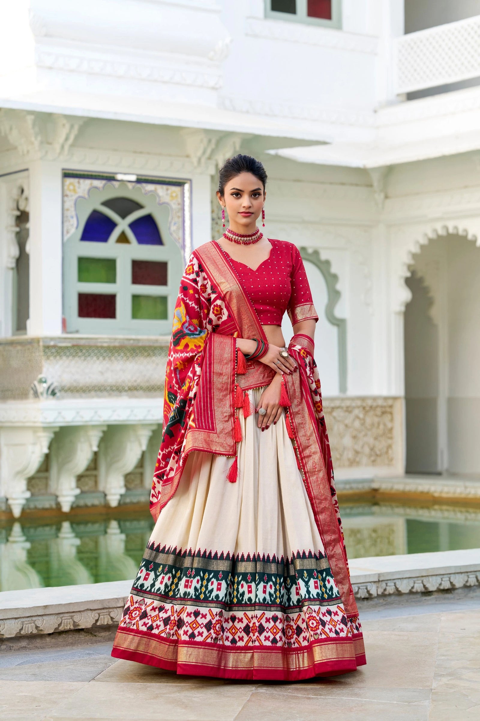 Woman in a traditional outfit with a colorful sari in an elegant indoor setting.