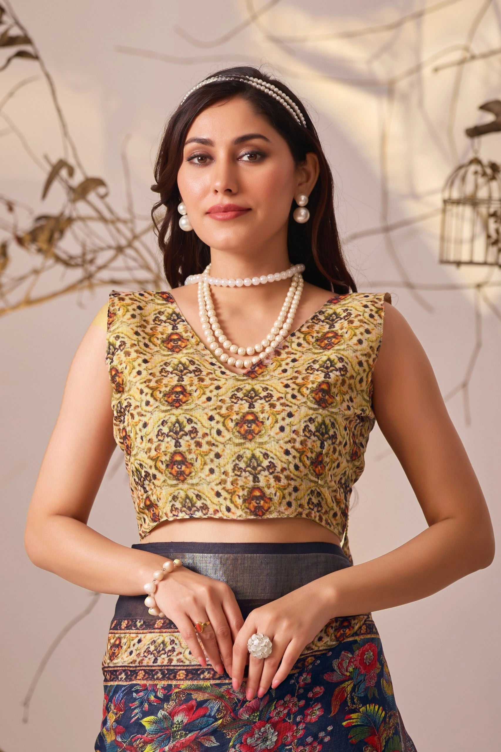 Woman wearing a traditional outfit with a floral top and skirt, standing against a neutral background.