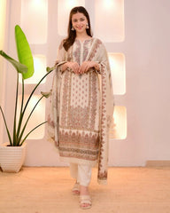 Woman in a traditional outfit standing indoors with decorative plants.