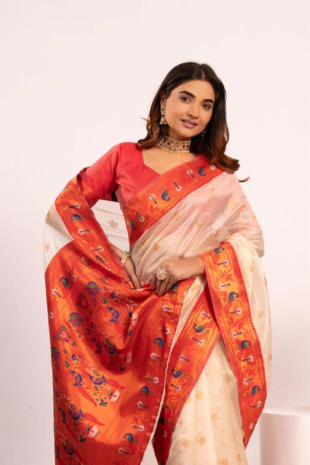 Woman wearing a red and white saree with a white background