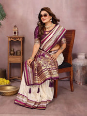 Woman in a traditional saree sitting on a chair with a decorative background