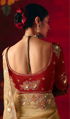 Woman wearing a red and gold embroidered blouse with a red background