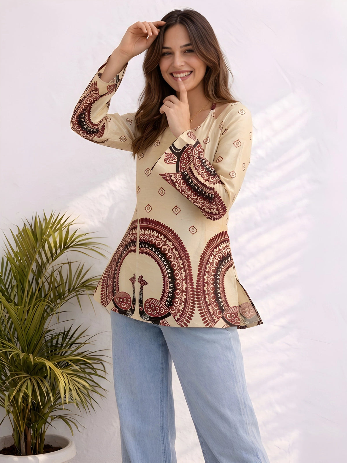 Woman wearing a patterned top with a plant in the background
