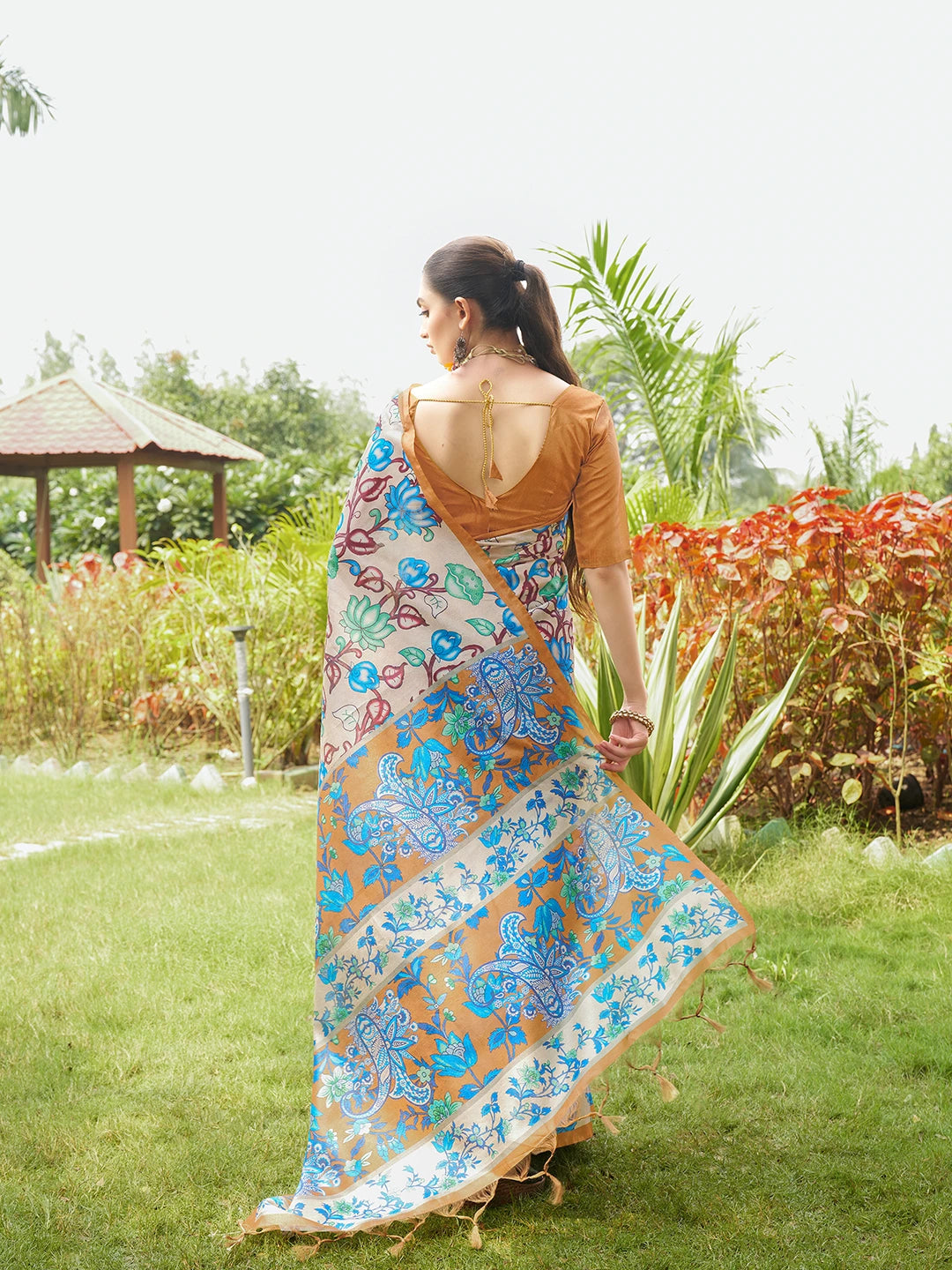 Beautiful beige floral print saree featuring a rich copper woven pallu and traditional ethnic design.