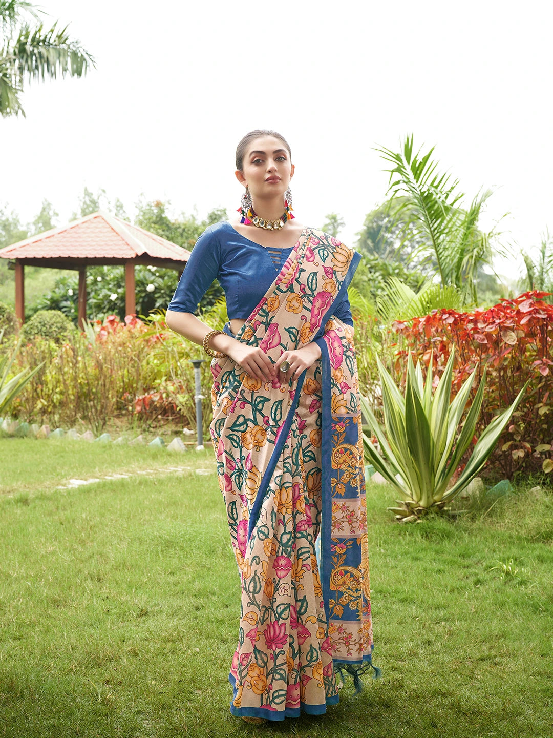 Premium beige floral printed saree with artistic blue woven pallu and elegant traditional look.
