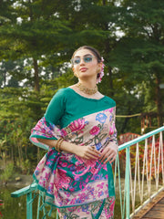 Elegant teal green floral printed saree with intricate woven border and matching blouse in a garden setting