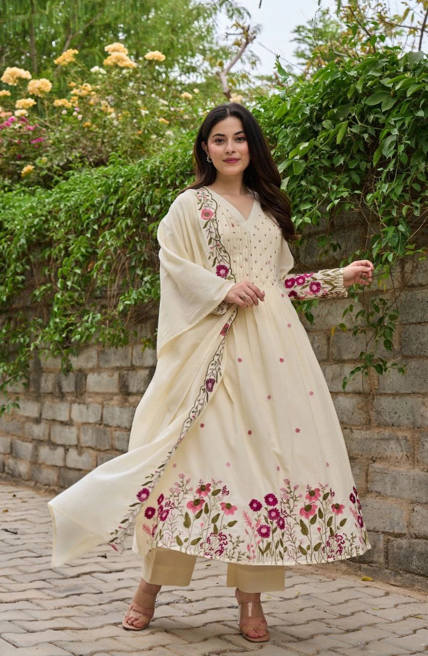 Woman in a floral dress standing outdoors with greenery in the background