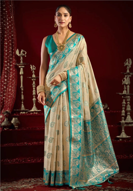 Woman wearing a traditional saree with a decorative border in a richly decorated room.