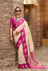 Woman wearing a pink and white saree against a stone wall.