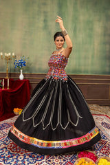 Black rayon lehenga with Kutchi choli and colorful patola border, dance pose front view