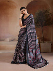 Woman wearing a traditional saree in an indoor setting with neutral colors.