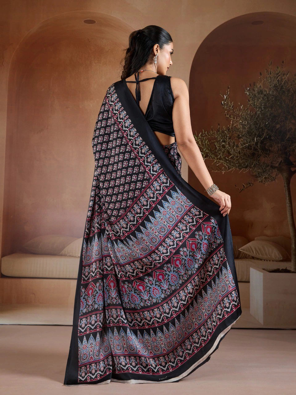 Woman wearing a black and white patterned saree in an indoor setting