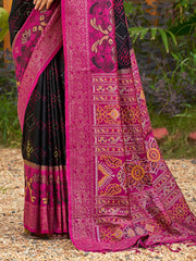 Black and pink saree with intricate patterns on a natural background