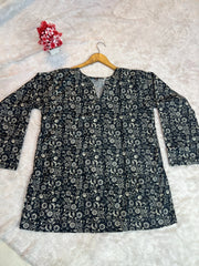 Floral-patterned shirt on a hanger against a textured white background