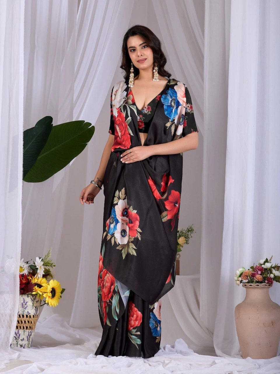 Woman wearing a black floral dress against a white curtain background