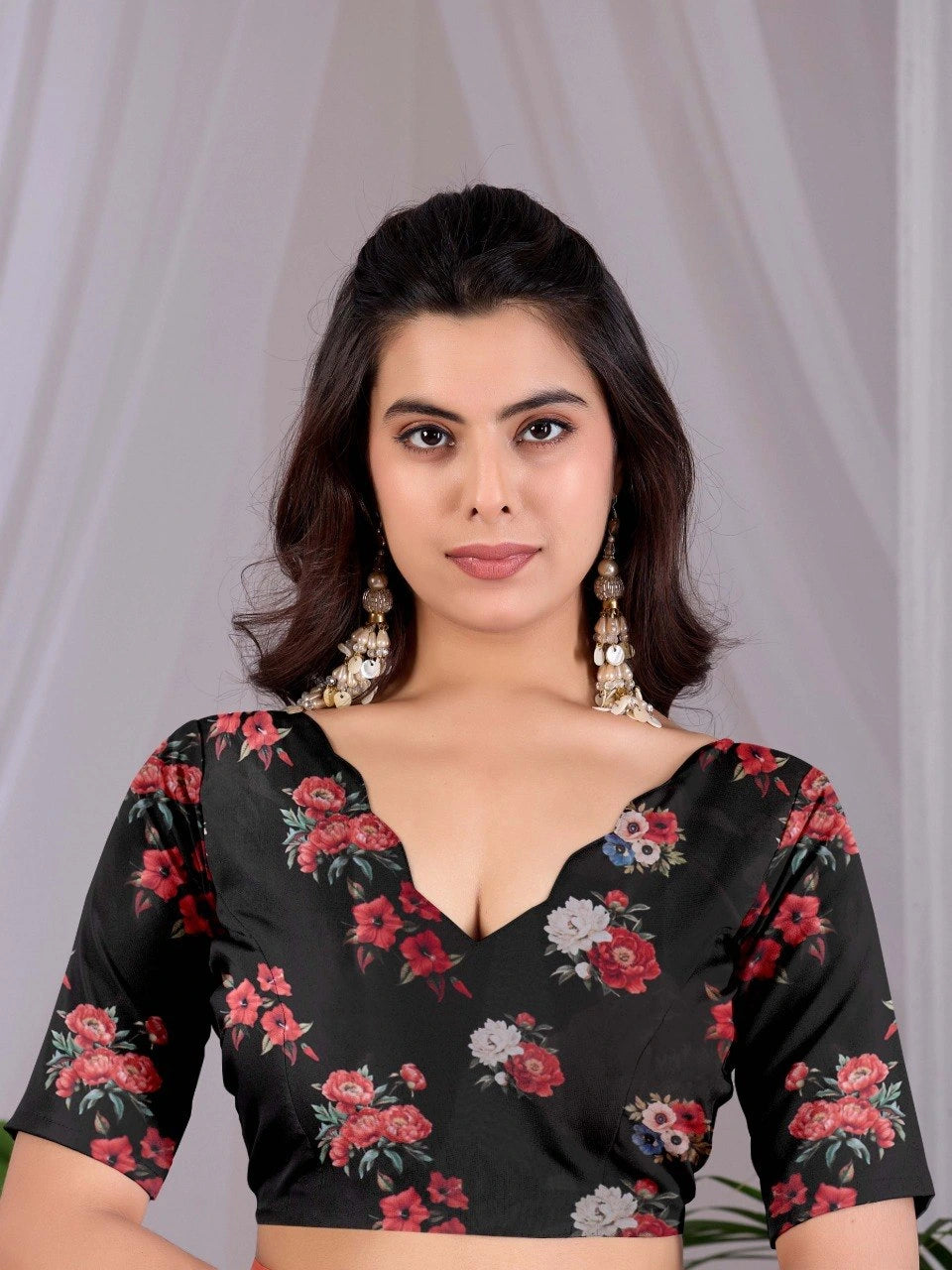 Woman wearing a black floral blouse against a plain background