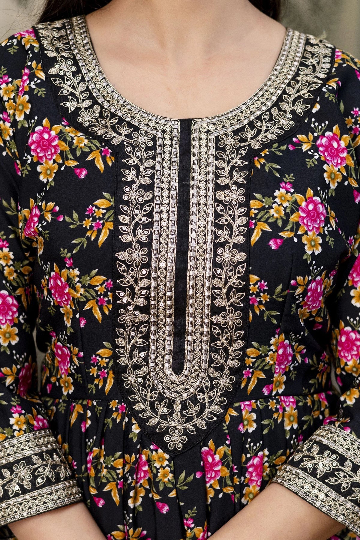Close-up of a black floral dress with intricate silver embroidery