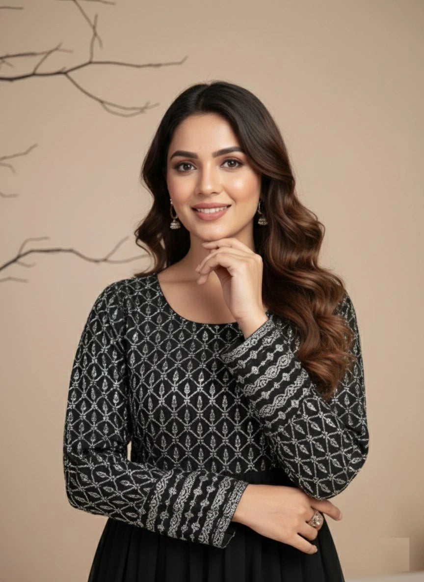 Woman wearing a black and gray patterned top against a beige background