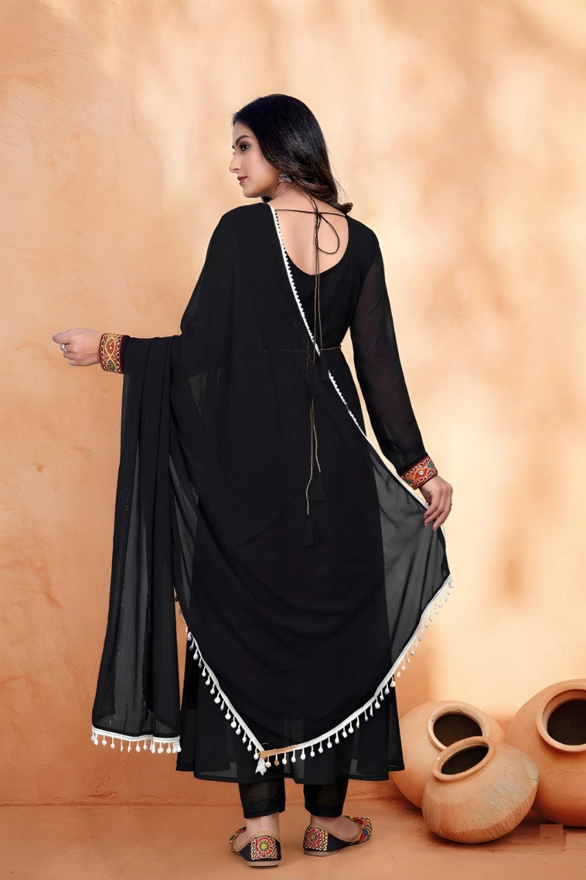 Woman in a black traditional outfit with a beige background