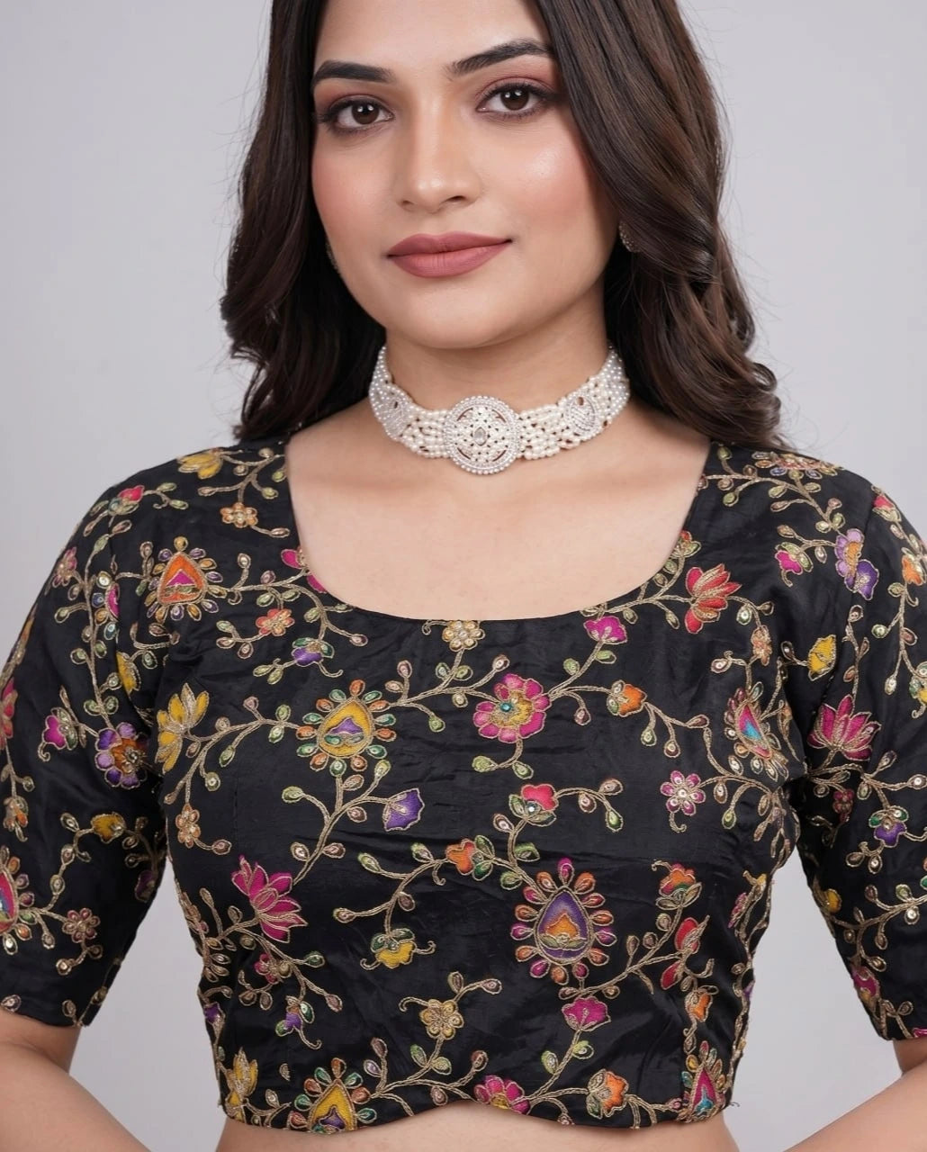 Close-up of black blouse highlighting fine embroidery and position print craftsmanship.
