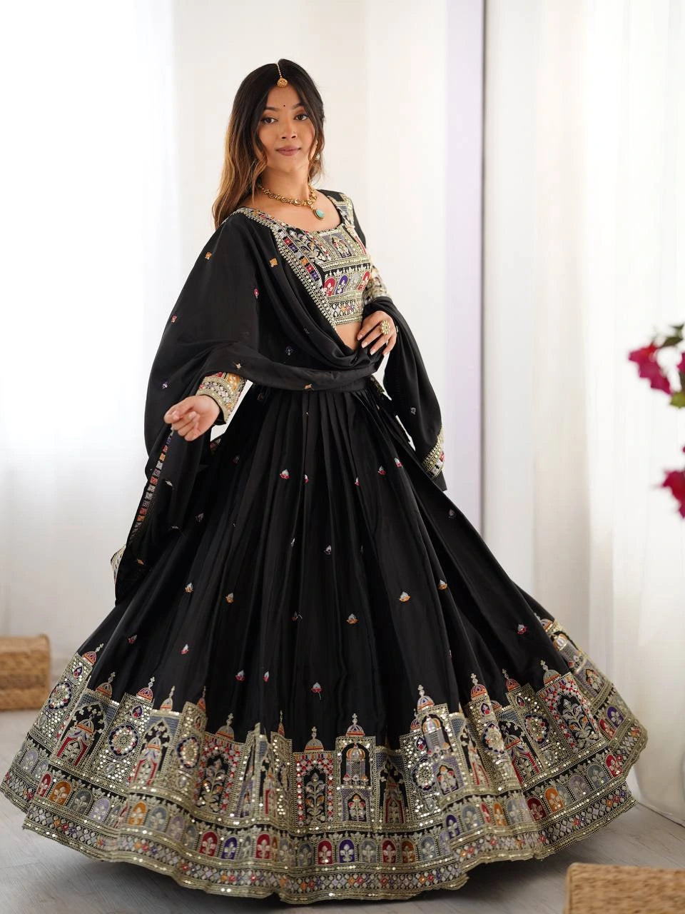 Woman wearing a black embroidered traditional outfit with a white background