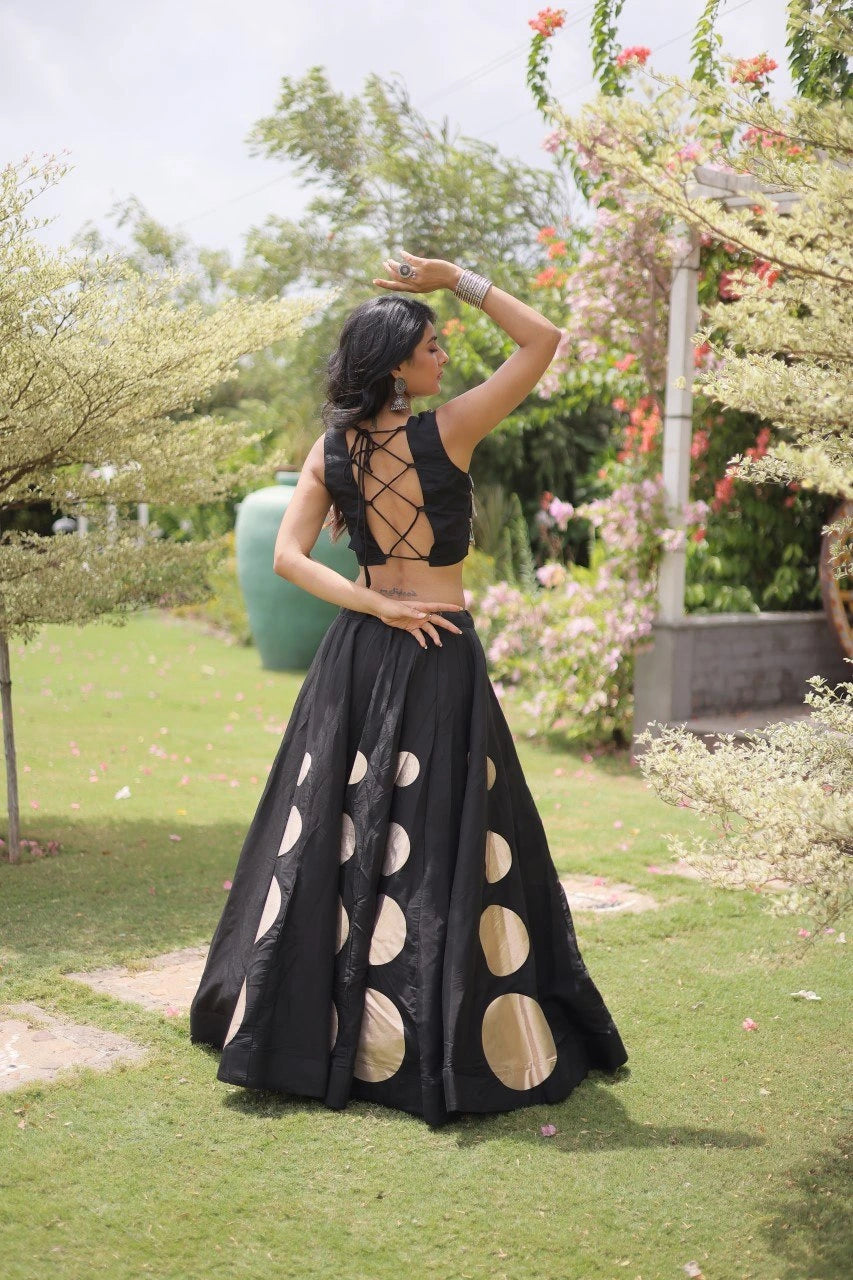 Eye-catching golden circular foil patterns add a bold and fashionable touch to the flowing black skirt.