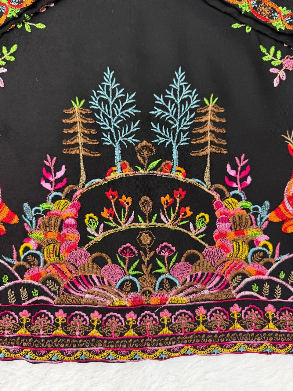 Colorful embroidered design on a black fabric background