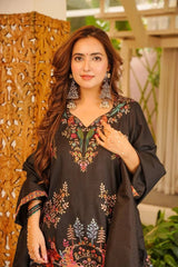 Woman wearing a black embroidered outfit with a decorative background