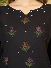 Black top with colorful floral embroidery on a blurred background