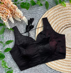 Black lace bralette on a textured surface with flowers and leaves.