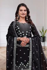 Woman wearing a black and white embroidered traditional outfit with a white background