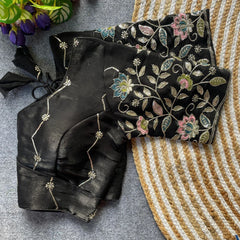 Black embroidered blouse with floral patterns on a textured surface