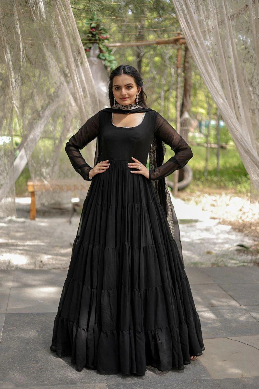 Woman wearing a black dress with sheer sleeves in an outdoor setting