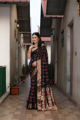 Woman in a traditional saree standing in an alleyway with buildings on either side.